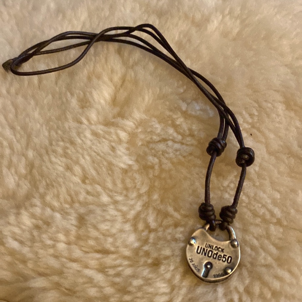 Padlock is silver on brown leather cord